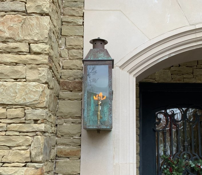 Copper oxidized Gas Flame with leaf pattern flame mounted on left side of front door