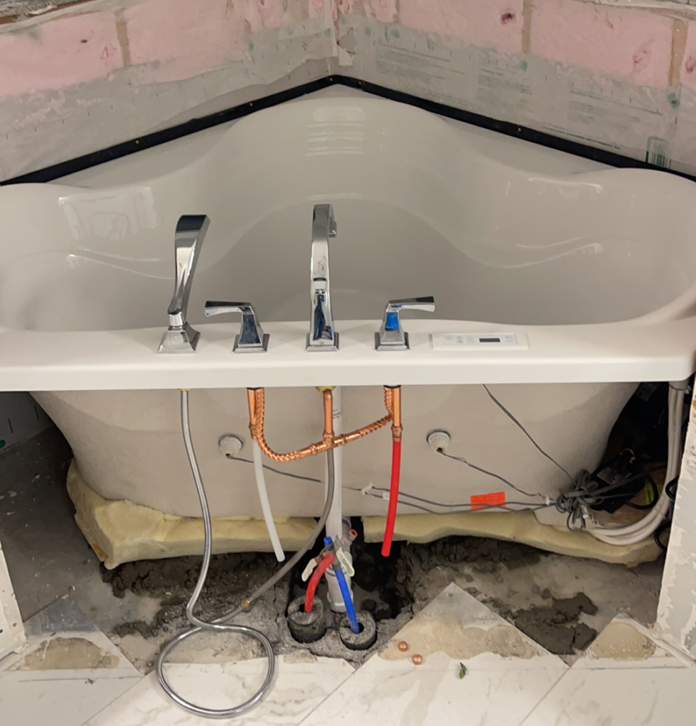 White Air Jet Corner Bathtub being installed by Vintage Plumbing